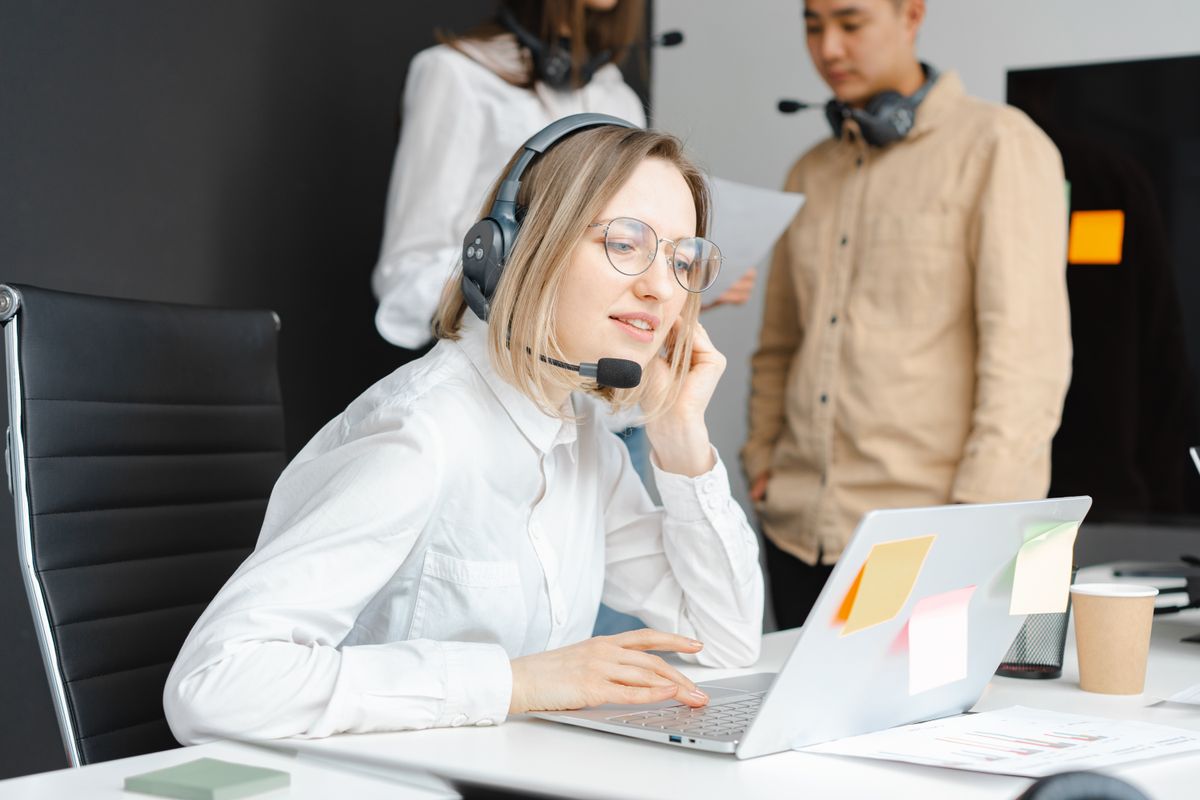 Profesionales trabajando con portátiles y auriculares